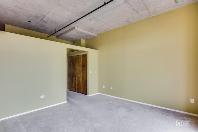 carpeted spare room featuring baseboards