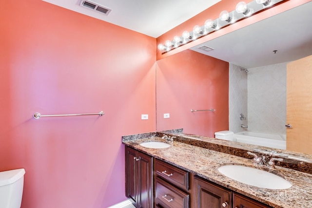 bathroom with visible vents, a sink, double vanity, and toilet