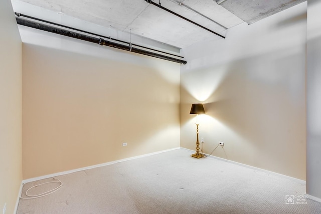 spare room featuring baseboards and carpet flooring