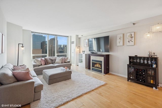 33 W Ontario St Unit 40D, Chicago, IL 60654 - living area with expansive windows, baseboards, wood finished floors, and a fireplace with flush hearth