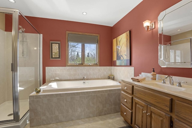 full bath featuring a stall shower, a garden tub, vanity, and tile patterned flooring