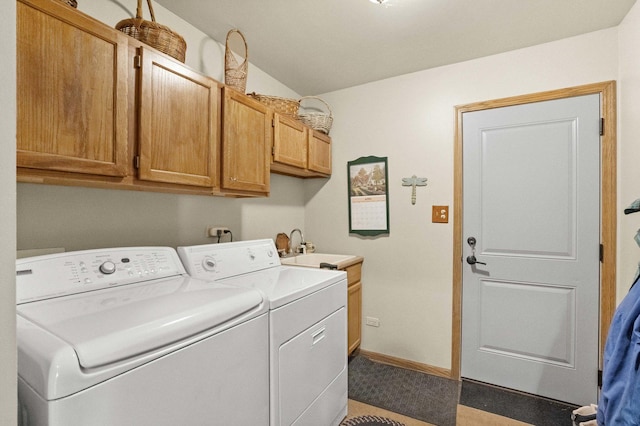 washroom with baseboards, separate washer and dryer, a sink, and cabinet space
