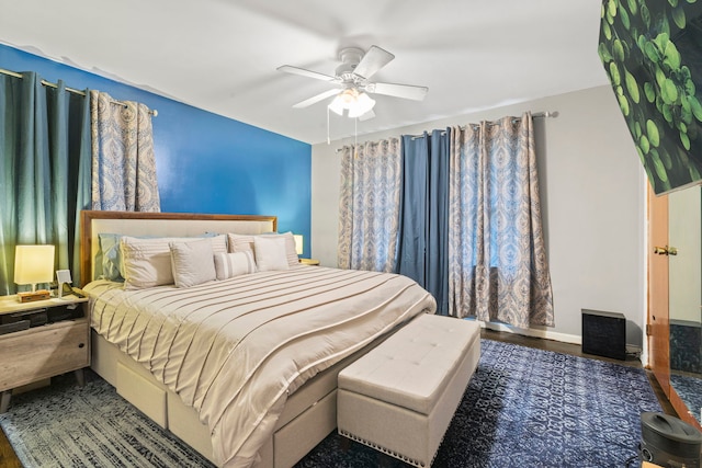 bedroom featuring wood finished floors, baseboards, and a ceiling fan