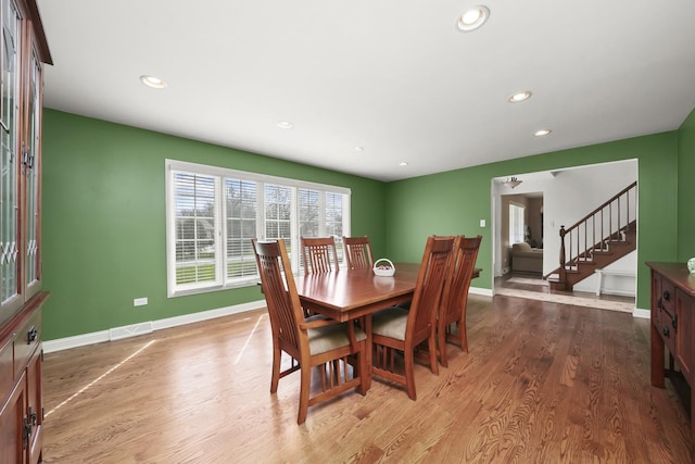 dining space featuring recessed lighting, stairs, baseboards, and wood finished floors