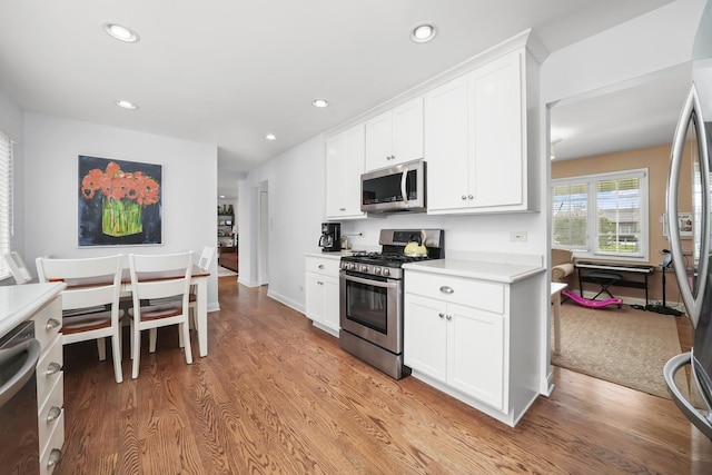 kitchen featuring light wood-type flooring, light countertops, recessed lighting, white cabinets, and appliances with stainless steel finishes
