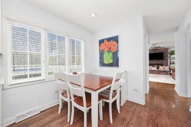 dining space with baseboards, a ceiling fan, wood finished floors, and visible vents
