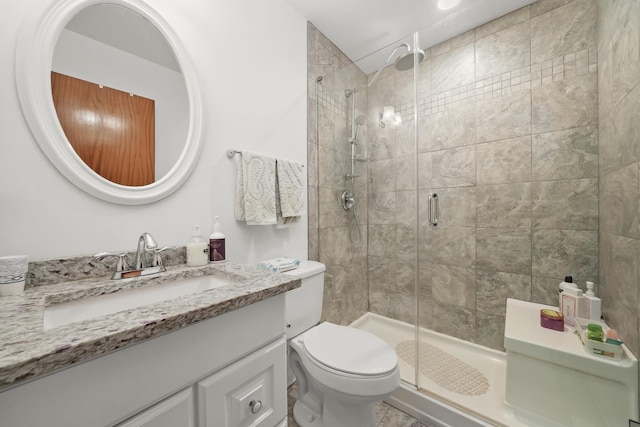 bathroom with toilet, a shower stall, and vanity