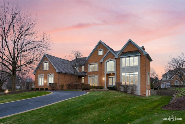 70 New Abbey Dr, Inverness, IL 60010 - view of front of home featuring aphalt driveway, a yard, brick siding, and a chimney