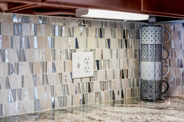 room details featuring stone counters and decorative backsplash