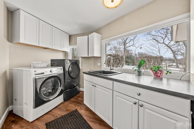 laundry area with baseboards, a sink, dark wood finished floors, cabinet space, and washing machine and dryer