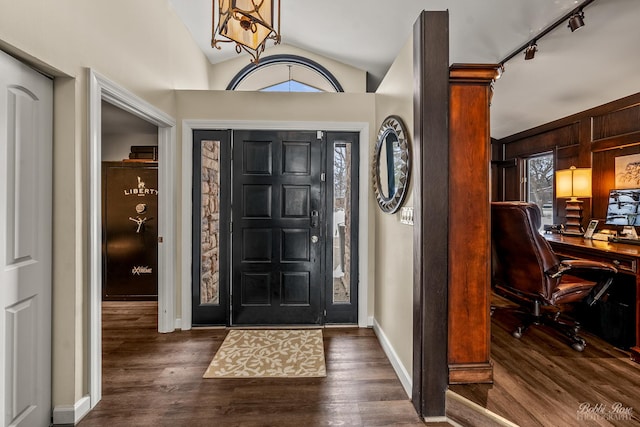 entrance foyer with baseboards, rail lighting, wood finished floors, and lofted ceiling