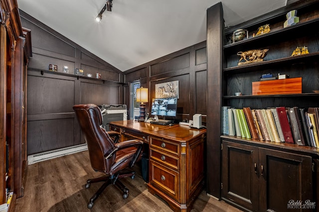 home office with a decorative wall, rail lighting, a baseboard heating unit, lofted ceiling, and dark wood-style floors
