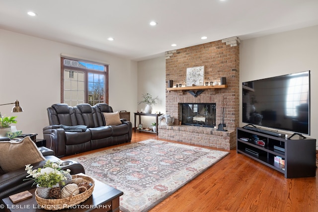 living room with wood finished floors, a fireplace, and recessed lighting