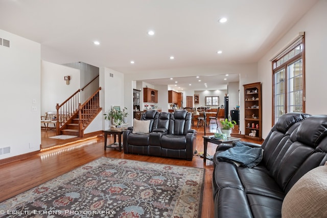 living area featuring wood finished floors, recessed lighting, visible vents, and stairway