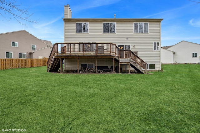 rear view of house with a lawn, stairway, fence, a chimney, and a deck