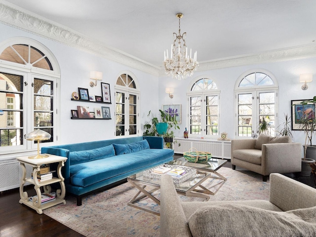 living area featuring ornamental molding, wood finished floors, and a chandelier