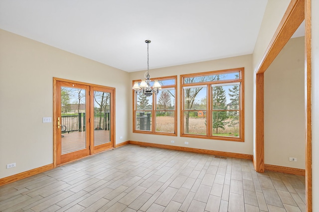 unfurnished dining area with baseboards, a notable chandelier, light wood finished floors, and visible vents