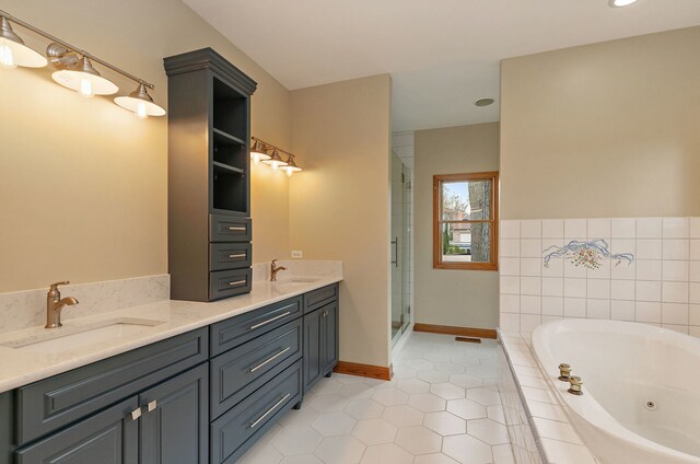 full bath featuring a sink, tile patterned floors, a tub with jets, and double vanity