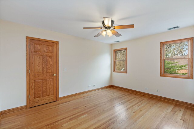 unfurnished room featuring a ceiling fan, baseboards, plenty of natural light, and light wood finished floors