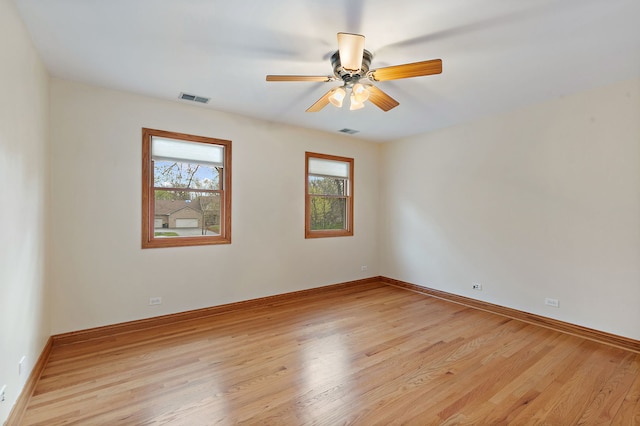 unfurnished room featuring ceiling fan, visible vents, baseboards, and light wood finished floors