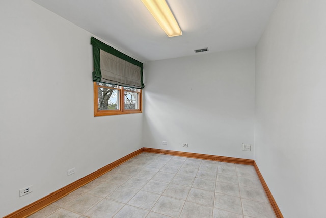 empty room featuring visible vents, baseboards, and light tile patterned floors