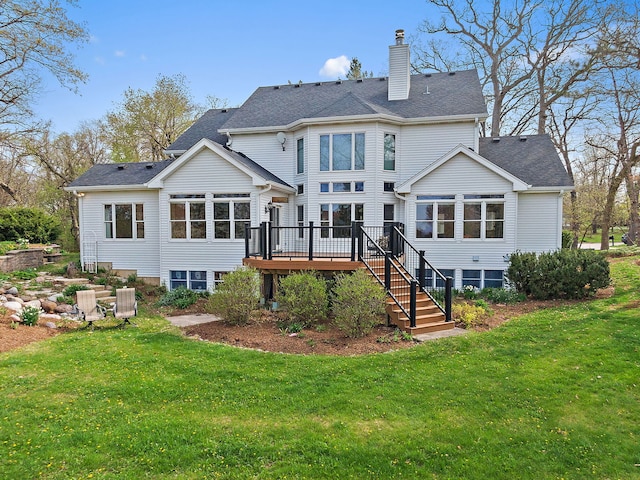 rear view of house featuring a lawn, stairway, a wooden deck, and a chimney