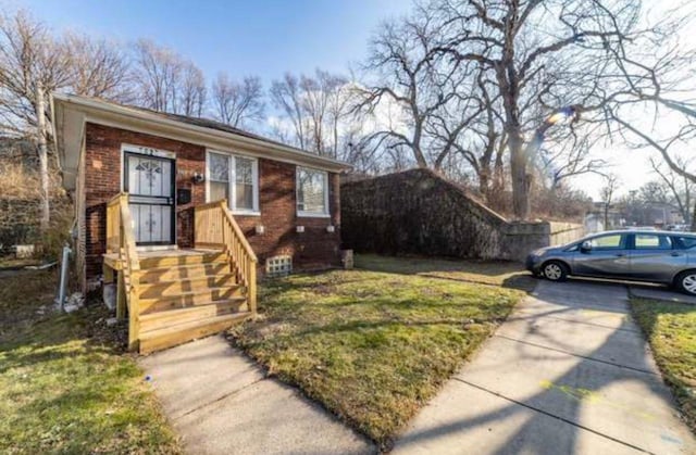 bungalow-style house with a front yard and brick siding