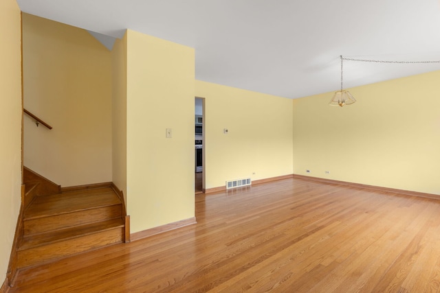 118 S Clarendon Ave, Addison, IL 60101 - empty room featuring light wood finished floors, baseboards, and stairs