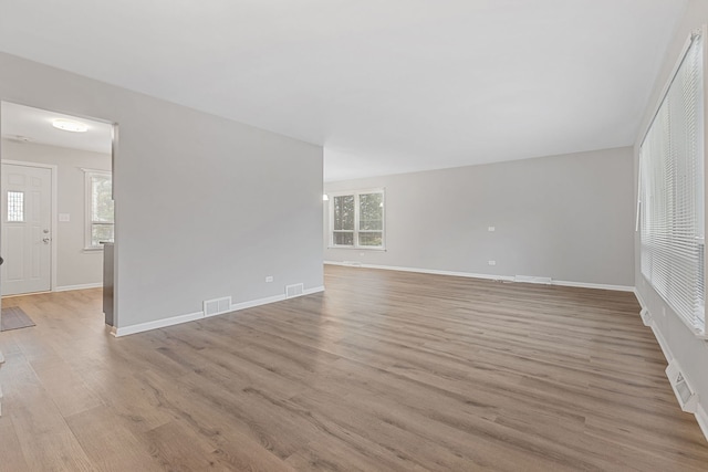 unfurnished living room with visible vents and light wood finished floors