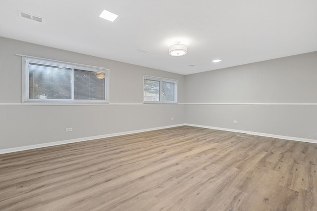 unfurnished room with light wood-style flooring, baseboards, and visible vents