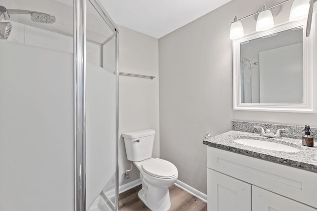 full bathroom featuring toilet, a shower stall, vanity, and wood finished floors