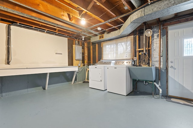 below grade area with a workshop area, a sink, water heater, and washer and clothes dryer