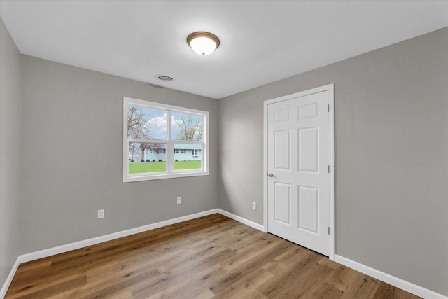 unfurnished bedroom with baseboards and wood finished floors