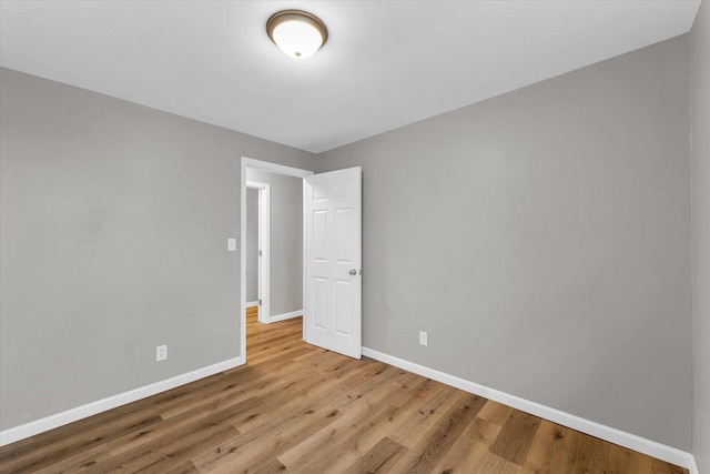 empty room with baseboards and wood finished floors