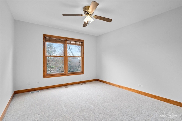 spare room with visible vents, a ceiling fan, carpet flooring, and baseboards