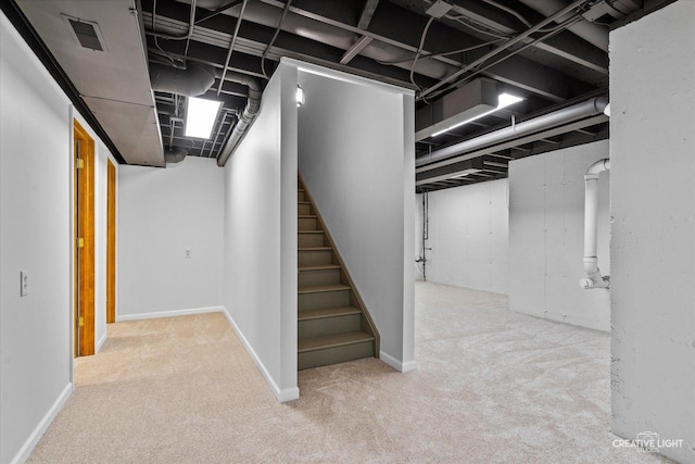 finished basement with visible vents, stairway, and carpet