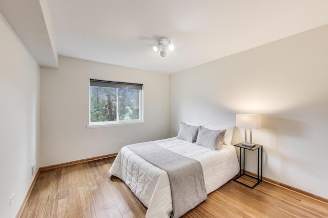 bedroom with light wood finished floors and baseboards