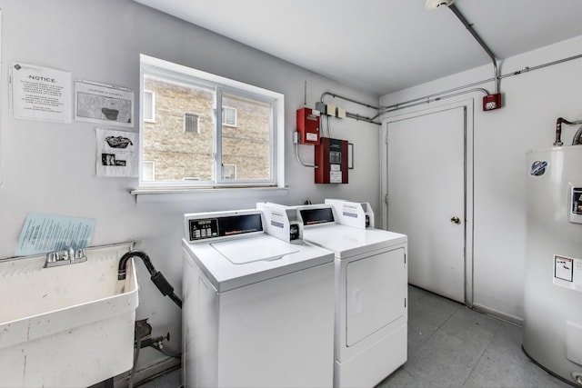 shared laundry area featuring washer and clothes dryer, a sink, and electric water heater