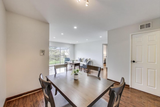 dining area with baseboards, wood finished floors, visible vents, and recessed lighting