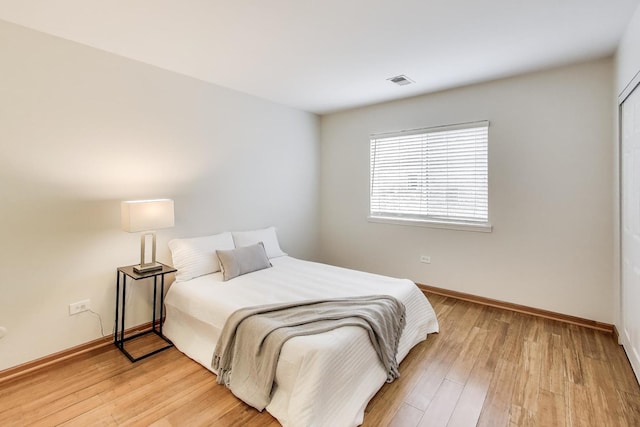 bedroom featuring baseboards, visible vents, and light wood-type flooring