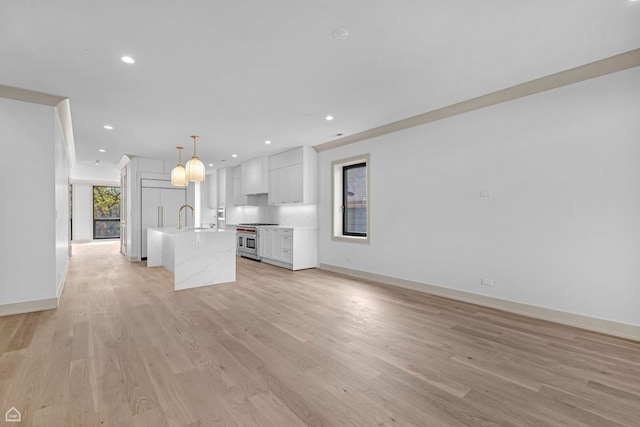 1646 N Orchard St Unit 3S, Chicago, IL 60614 - kitchen with range with two ovens, a sink, light countertops, white cabinetry, and a center island with sink