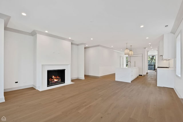 1646 N Orchard St Unit 3S, Chicago, IL 60614 - unfurnished living room with light wood-type flooring, recessed lighting, a warm lit fireplace, and baseboards