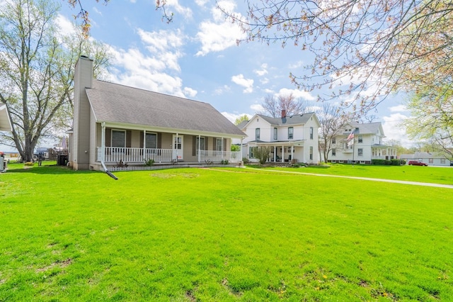 view of front of property featuring a chimney, a front lawn, and covered porch
