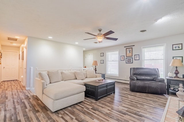living area with a ceiling fan, wood finished floors, visible vents, and recessed lighting