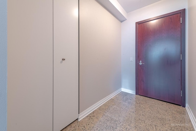 foyer entrance with baseboards and light speckled floor