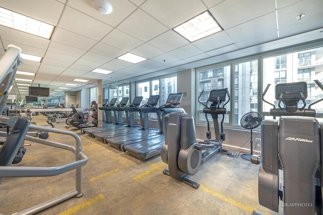 workout area with a drop ceiling and baseboards