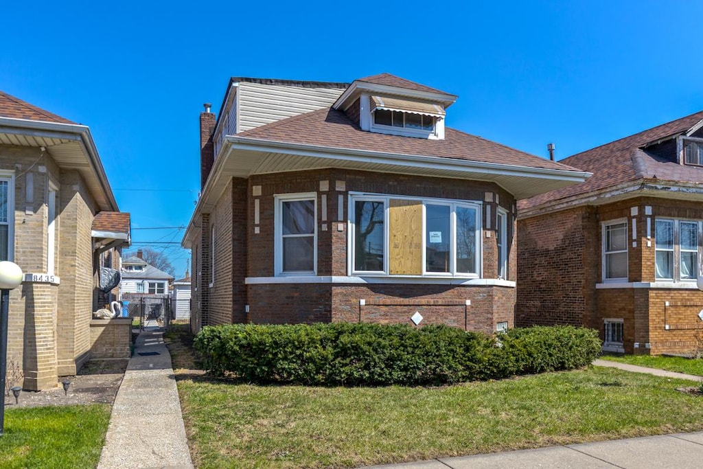 8439 S Ada St, Chicago, IL 60620 - bungalow-style house with roof with shingles, brick siding, and a front lawn