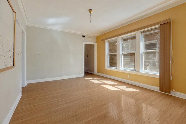 empty room featuring baseboards, ornamental molding, and hardwood / wood-style flooring
