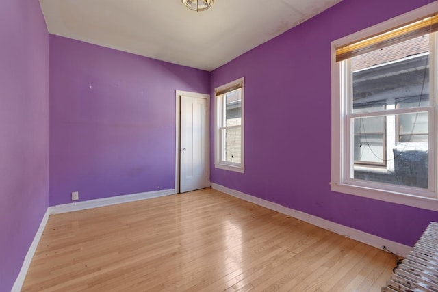 unfurnished room featuring light wood-style floors and baseboards