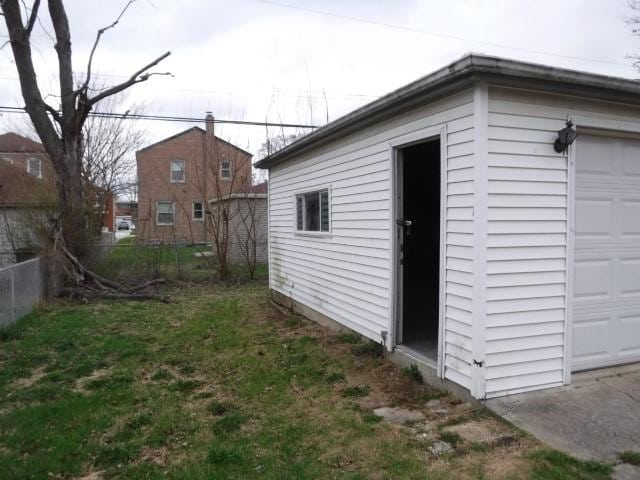 view of outdoor structure with a garage and fence
